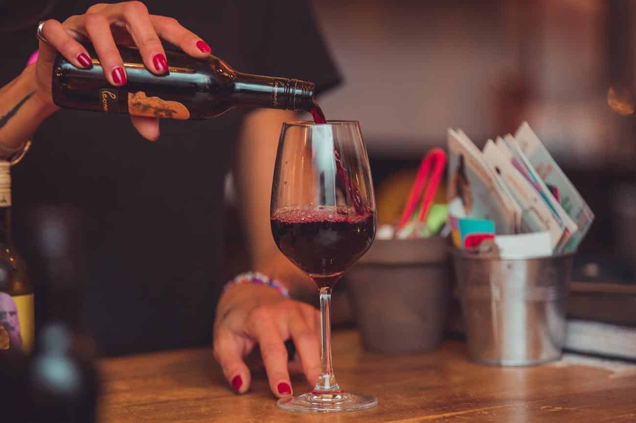 donna versa vino in un calice