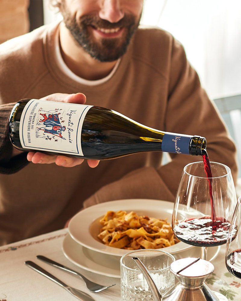 mano versa vino rosso vigneti romio in un calice